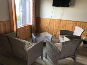 een kamer met stoelen, een tafel en een televisie bij CABAÑAS ANAHUAC in Puerto Montt