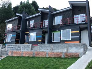 a black house with a brick retaining wall at CABAÑAS ANAHUAC in Puerto Montt