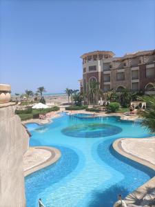 una piscina en un complejo con agua azul en Tony's Privy One bed by Red Sea en Hurghada