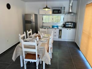 kuchnia ze stołem i krzesłami w kuchni w obiekcie Apart del Este 4 w mieście Paysandú