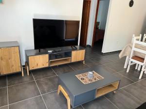 Apart del Este 4 في بايساندو: غرفة معيشة مع تلفزيون بشاشة مسطحة وطاولة