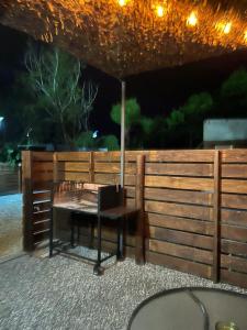 a table with an umbrella in front of a fence at Apart del Este 4 in Paysandú