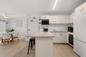 卡倫德拉的住宿－Cheltenham Apartments Unit 4 40 King St，厨房配有白色橱柜和桌椅