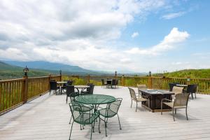 a deck with tables and chairs with mountains in the background at Smoke of the Mountains in Gatlinburg