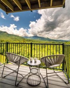 two chairs and a table on a deck with a view at Serenity Bliss in Gatlinburg