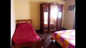 1 dormitorio con 2 camas y vestidor con espejo en Chacra Lo de Chicharra en Gualeguay