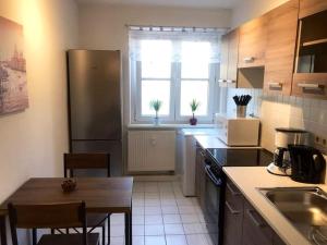 a small kitchen with a table and a refrigerator at Apartment „Vikings“ / Lifestyle in Leipzig