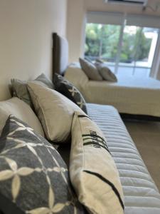 un sofá con almohadas en la sala de estar en Espectacular departamento en pleno centro en Resistencia