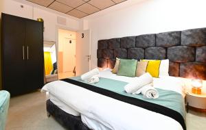 - une chambre avec un grand lit et des serviettes dans l'établissement Yalarent Malina motel in Tiberias, à Tibériade