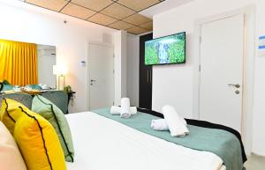 a hotel room with a bed with a flat screen tv at Yalarent Malina motel in Tiberias in Tiberias