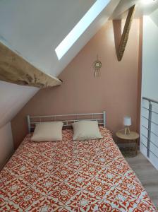 a bedroom with a large bed with two pillows at Studio des Monts Caubert in Mareuil-Caubert