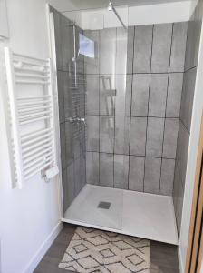 La salle de bains est pourvue d'une douche avec une porte en verre. dans l'établissement Studio des Monts Caubert, à Mareuil-Caubert