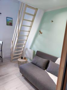 - un salon avec un canapé et un escalier dans l'établissement Studio des Monts Caubert, à Mareuil-Caubert
