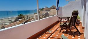 uma varanda com mesa e cadeiras e vista para o oceano em Céntrico ático junto al mar em Rincón de la Victoria