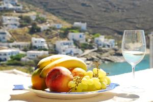 um prato de fruta numa mesa com um copo de vinho em Aelia Mare Penthouse em Istérnia