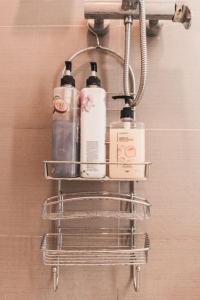 a towel rack with four bottles on a wall at Modern Tropical Luxe Apartment - Ilig-Iligan Beach in Boracay