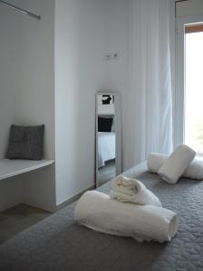 a white room with a bed and a mirror at Nera's view in Ancient Epidauros