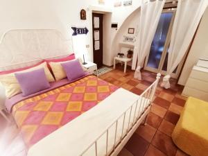 1 dormitorio con 1 cama grande con almohadas moradas y amarillas en Blanco's home, en Nápoles