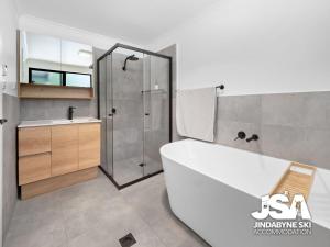 a bathroom with a tub and a shower and a sink at Casa Della Vita in Jindabyne +20 photos
