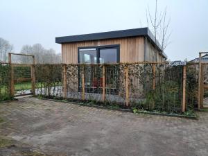 une maison construite au-dessus d'une clôture dans l'établissement Luxe 5 persoons bungalow op rustig vakantiepark nabij Leeuwarden, à Dronrijp