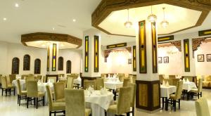 a dining room with white tables and chairs at El Yacouta in Tétouan