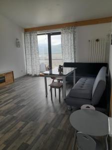 ein Wohnzimmer mit einem Sofa und einem Tisch in der Unterkunft Casa Prieteniei - camere - 3 km Piatra Neamț in Piatra Neamţ