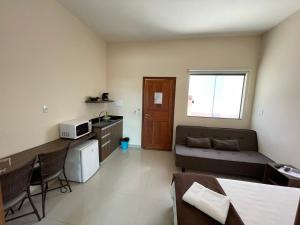 a small living room with a couch and a table at Pousada Encantos de Capitolio in Capitólio