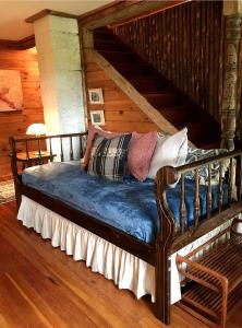 a large wooden bed in a room with wooden floors at Adirondack Cottage Retreat in Elizabethtown