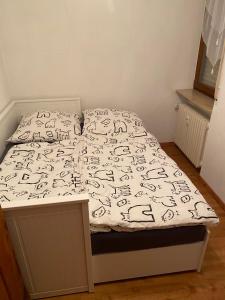 Cama con sábanas y almohadas blancas y negras en Ferienwohnung am See, Überlingen, en Überlingen