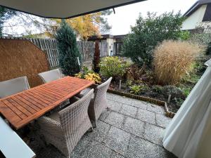 Una mesa y sillas de madera en un patio. en Ferienwohnung am See, Überlingen, en Überlingen