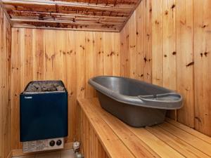 a bath tub in a wooden room with a stove at 10 person holiday home in B rkop in Egeskov