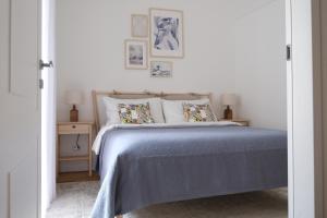 - une chambre avec un lit doté de draps et d'oreillers bleus dans l'établissement Ventisei, à Catane