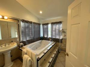 a large bathroom with a tub and a sink at Casa de Abuelos, 2bd guest house, Jacuzzi, Biola, Disney, Knotts, LAX in Whittier