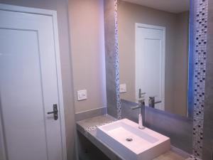 a bathroom with a white sink and a mirror at PIRAGIBE FROTA AGUIAR in Rio de Janeiro