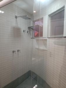 baño con ducha y puerta de cristal en PIRAGIBE FROTA AGUIAR, en Río de Janeiro