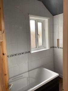 a white bath tub in a bathroom with a window at Hope Corner in Filey
