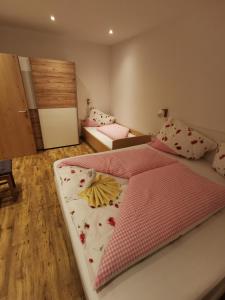1 dormitorio con 2 camas con sábanas rosas y blancas en Apart Emilia, en Schönwies