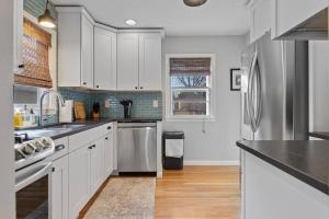 a kitchen with white cabinets and stainless steel appliances at Walk to Parks Pet Friendly Top Neighborhood in Rapid City