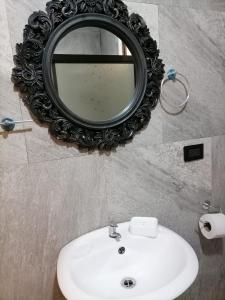 um espelho sobre um lavatório branco na casa de banho em Mer-Anthu em Tortuguero