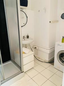 a bathroom with a shower and a washing machine at Radisson Charm Studio in Bucharest