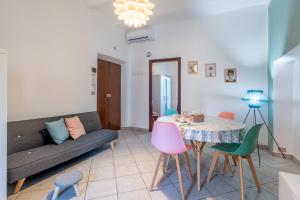 een woonkamer met een bank en een tafel en stoelen bij La Verde Rosa - Casa vacanze a due passi dal lago in Marta