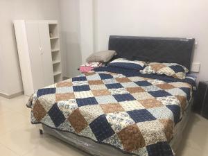 um quarto com uma cama com uma colcha em Monoambiente en Ciudad del Este - Py em Ciudad del Este