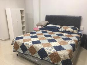 1 dormitorio con 1 cama con edredón en Monoambiente en Ciudad del Este - Py, en Ciudad del Este