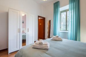 een slaapkamer met handdoeken op een bed met een raam bij La Verde Rosa - Casa vacanze a due passi dal lago in Marta