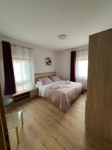 a bedroom with a bed and two windows at Stanjkov smještaj in Donji Kraljevec