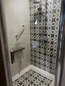 een douche met zwarte en witte tegels bij Stanjkov smještaj in Donji Kraljevec