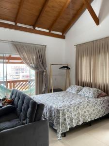 a bedroom with a bed and a couch at Studio Recanto Beach Itapema in Itapema