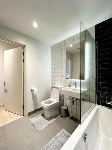 a bathroom with a toilet and a sink and a tub at Stunning 1 Bedroom Apartment in London