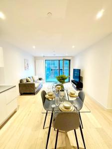 a dining room with a table and chairs and a couch at Stunning 1 Bedroom Apartment in London