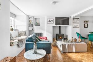 a living room with a couch and a fireplace at Crooks Cottage - Charming, characterful, glorious views from the garden in Dittisham